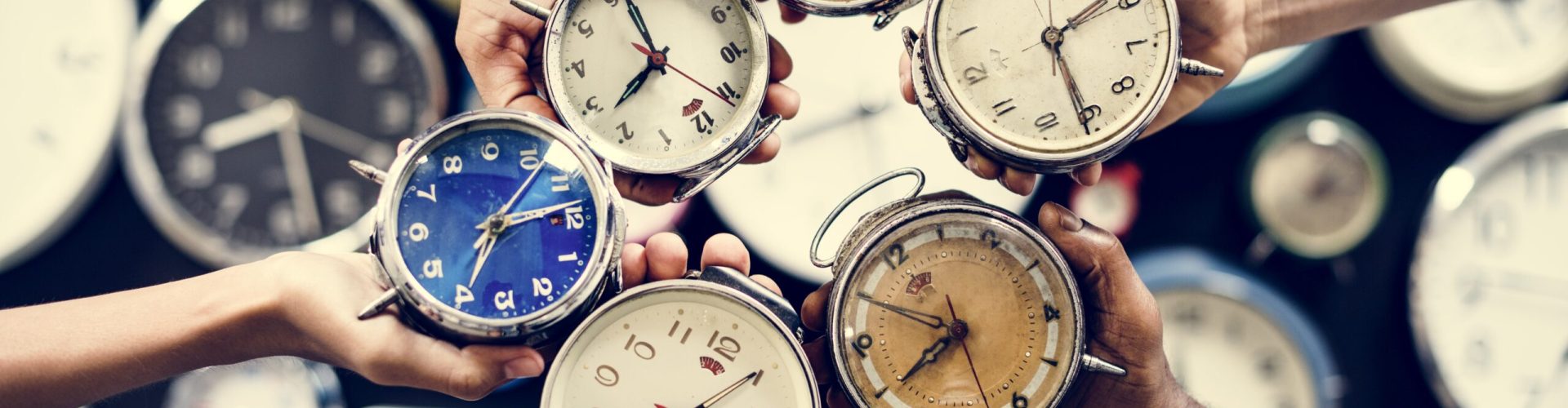 Hands holding clocks